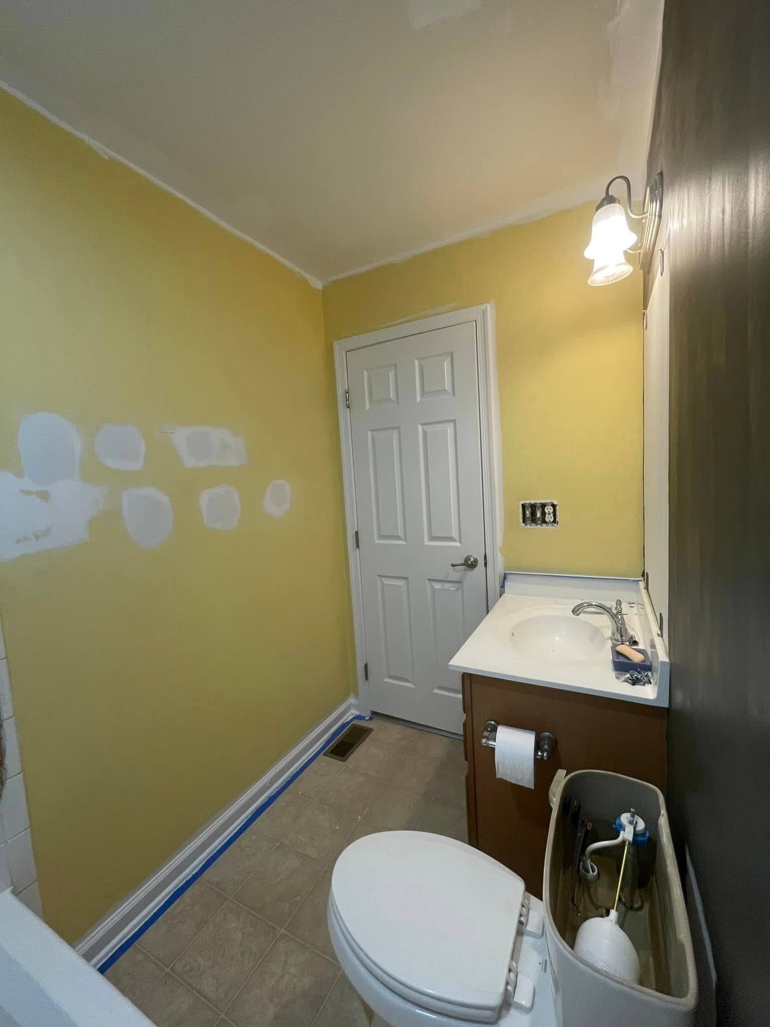 A bathroom with a toilet , sink , and mirror.