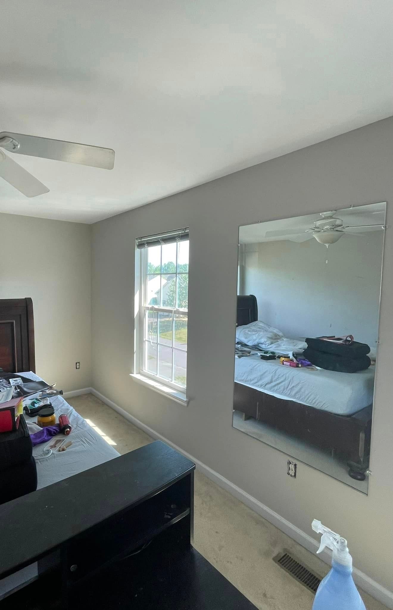 A bedroom with a large mirror on the wall and a bed.