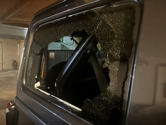 A car with a broken window in a garage