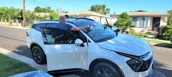 A man is sitting in the driver 's seat of a white suv.