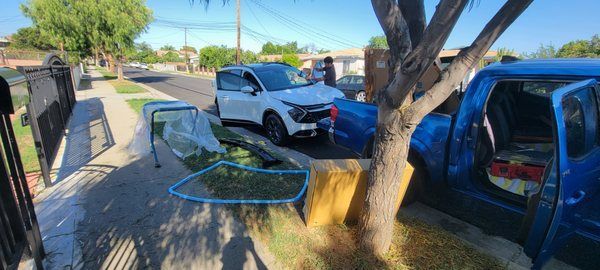 A blue truck is parked next to a white suv on the side of the road.