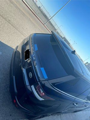 A black car is parked on the side of the road.