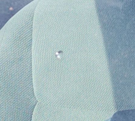 A close up of a piece of fabric with a drop of water on it.