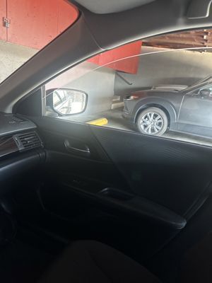 A car is parked in a parking garage next to another car.