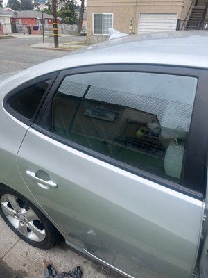 A silver car is parked on the side of the road.