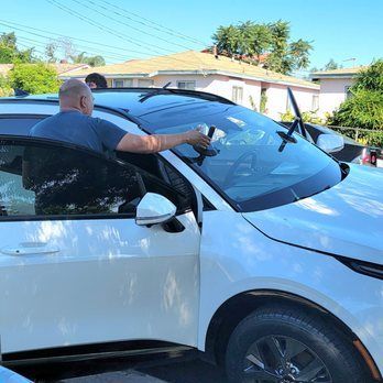 A man is getting out of a white car.