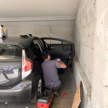A man is working on a car in a garage.