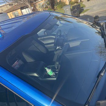 A blue car with a bottle of water in the passenger seat.