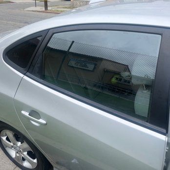 A silver car is parked on the side of the road.