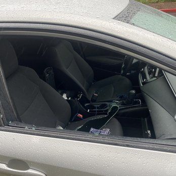 A white car with black seats is parked in a parking lot.