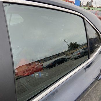 A close up of a car window with a reflection of cars in it.