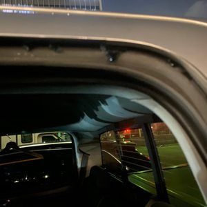 A car is parked on the side of the road at night.