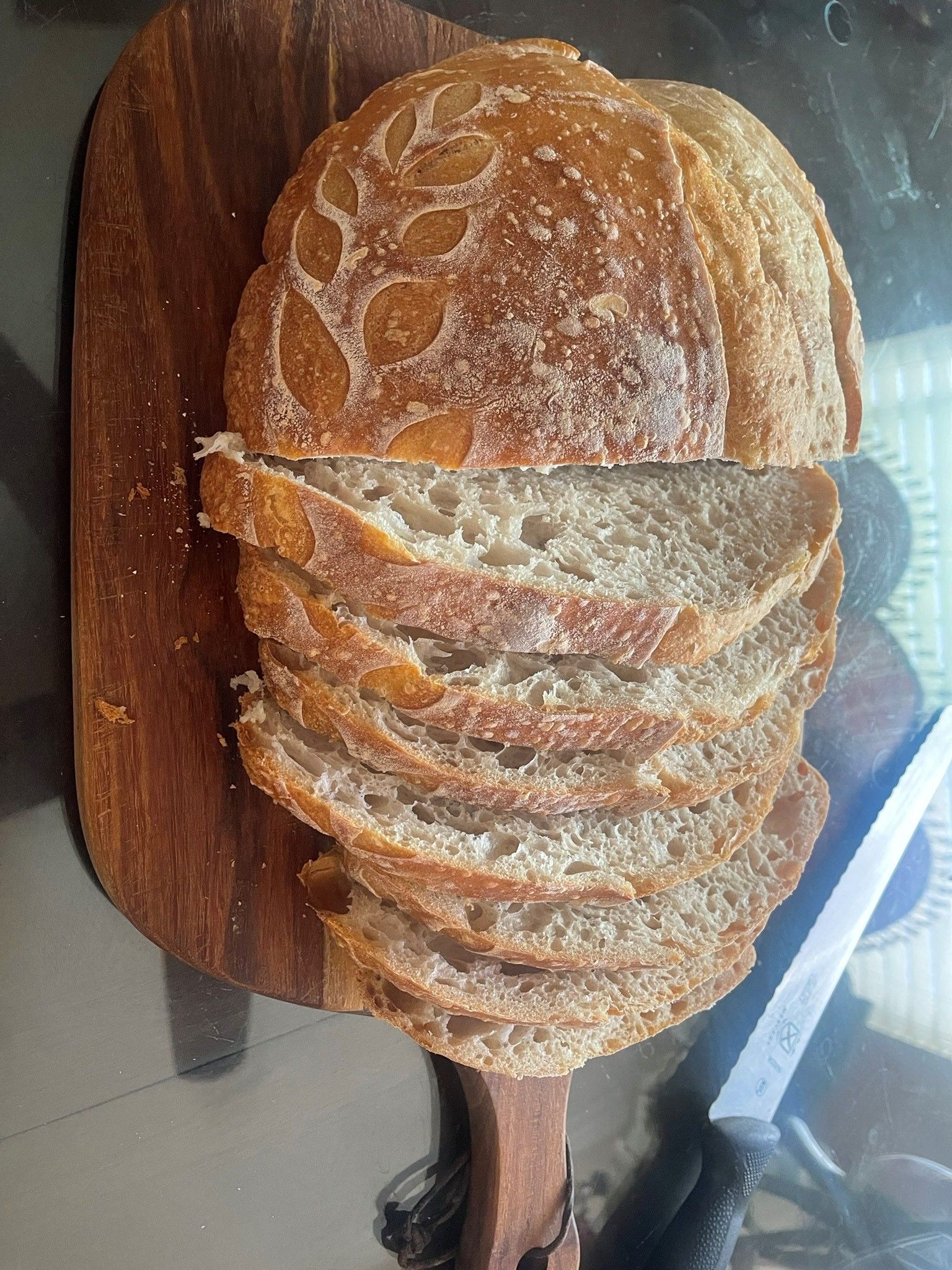 A loaf of bread is sitting on a wooden cutting board.