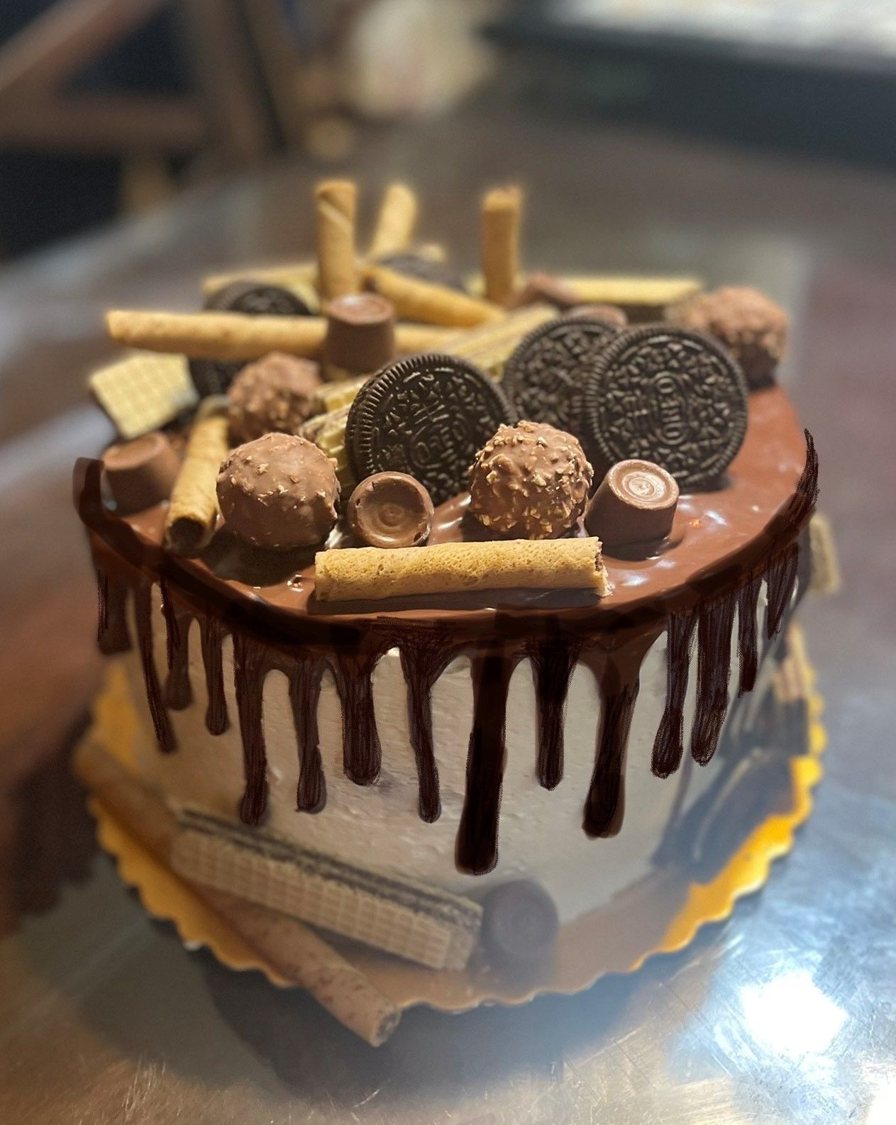 A chocolate cake with oreos and other chocolates on top