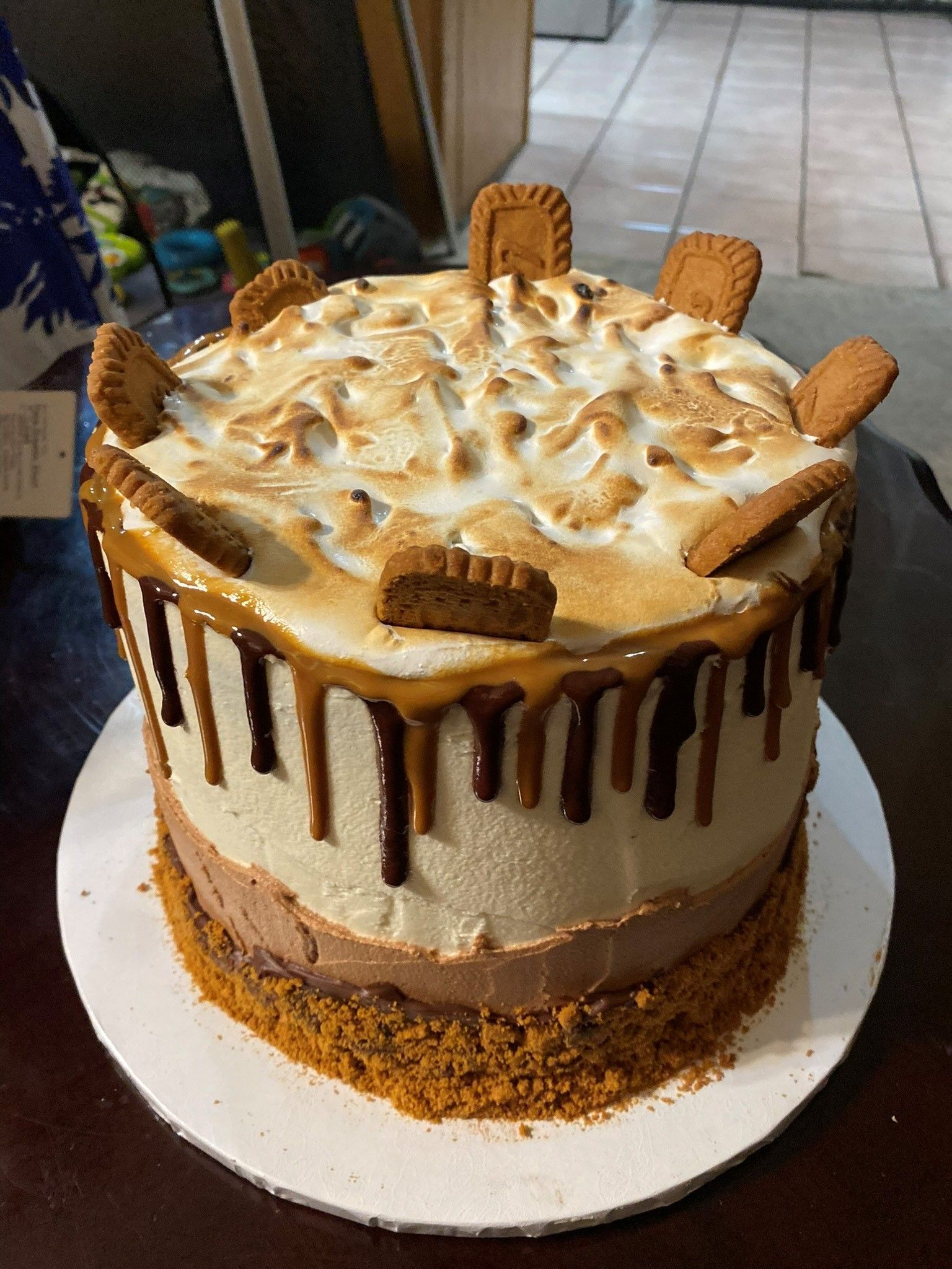 A cake with lots of cookies on top of it on a table.