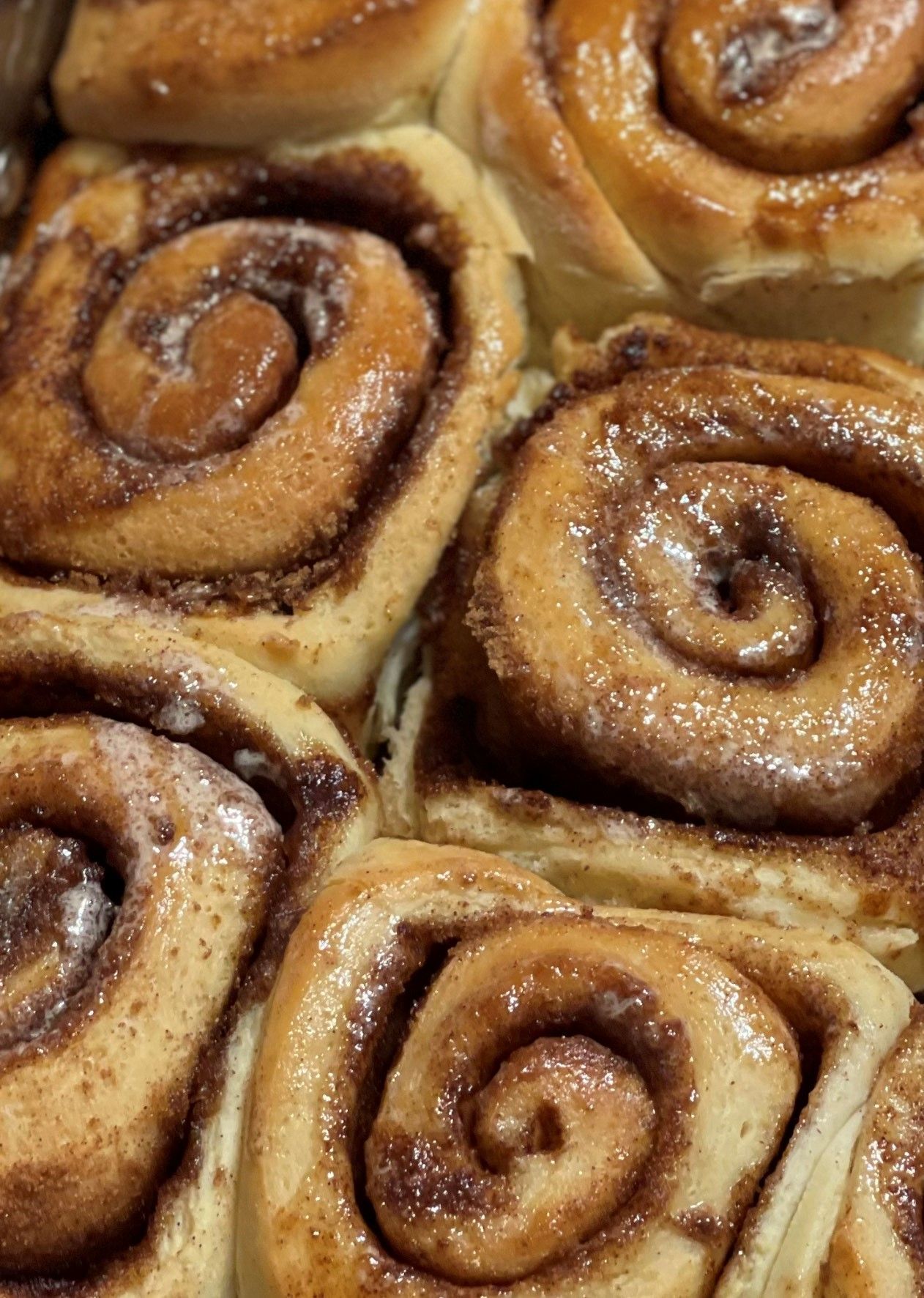 A bunch of cinnamon rolls are sitting on top of each other on a table.