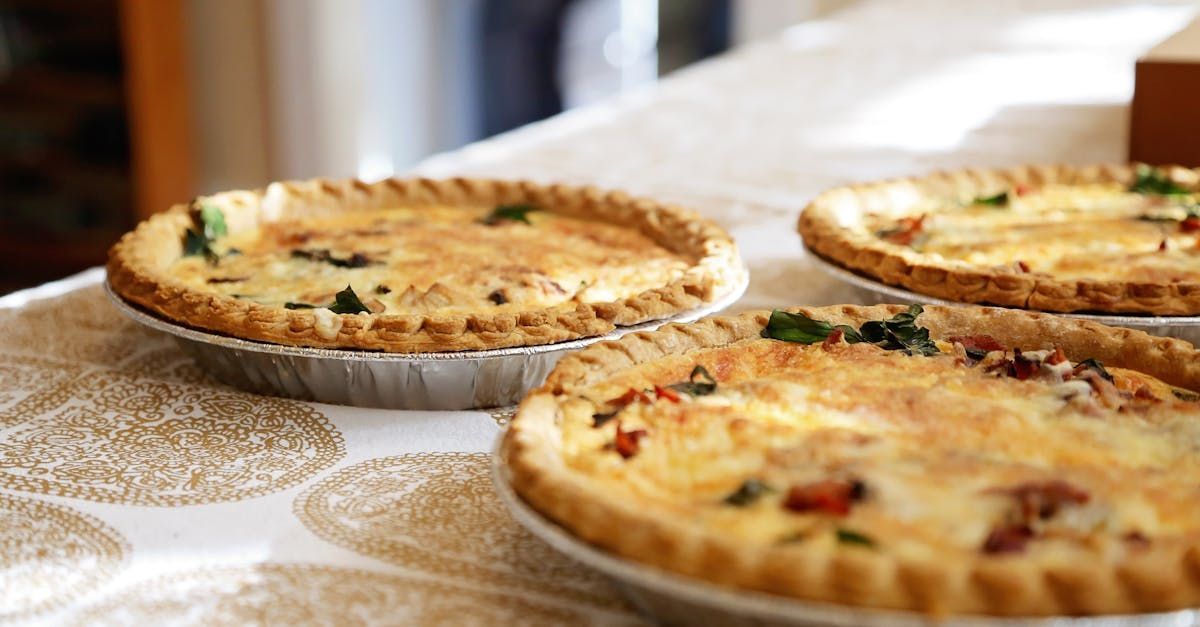 Three quiches are sitting on a table.