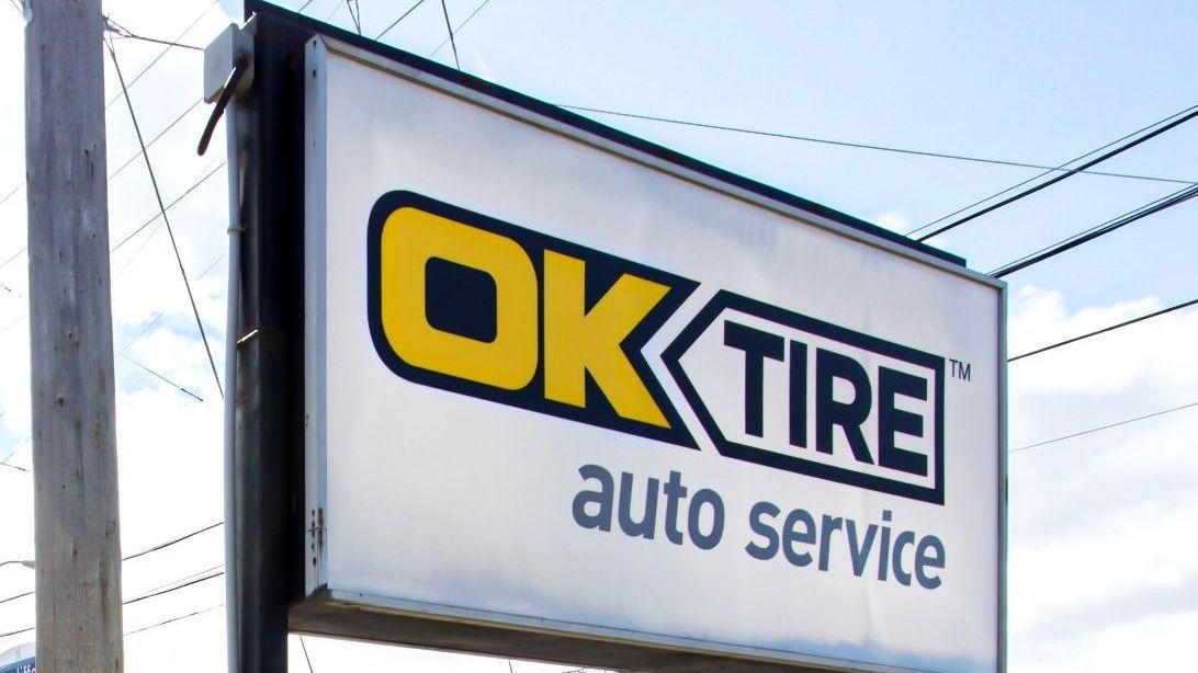Sign for OK Tire auto service, logo with yellow