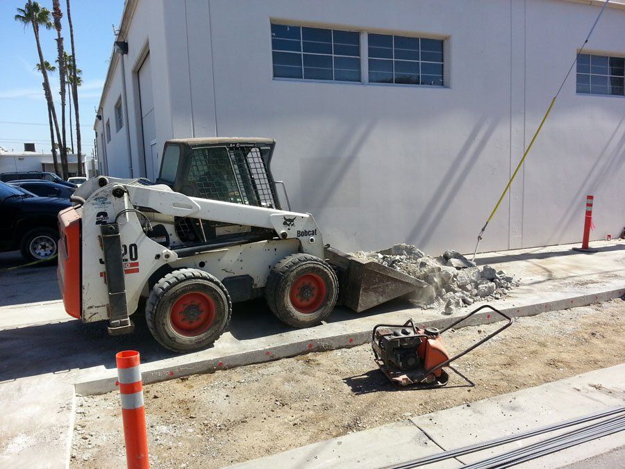 Excavator Demolishing Residential Driveway — Mira Loma, CA — Sneve Bobcat Service