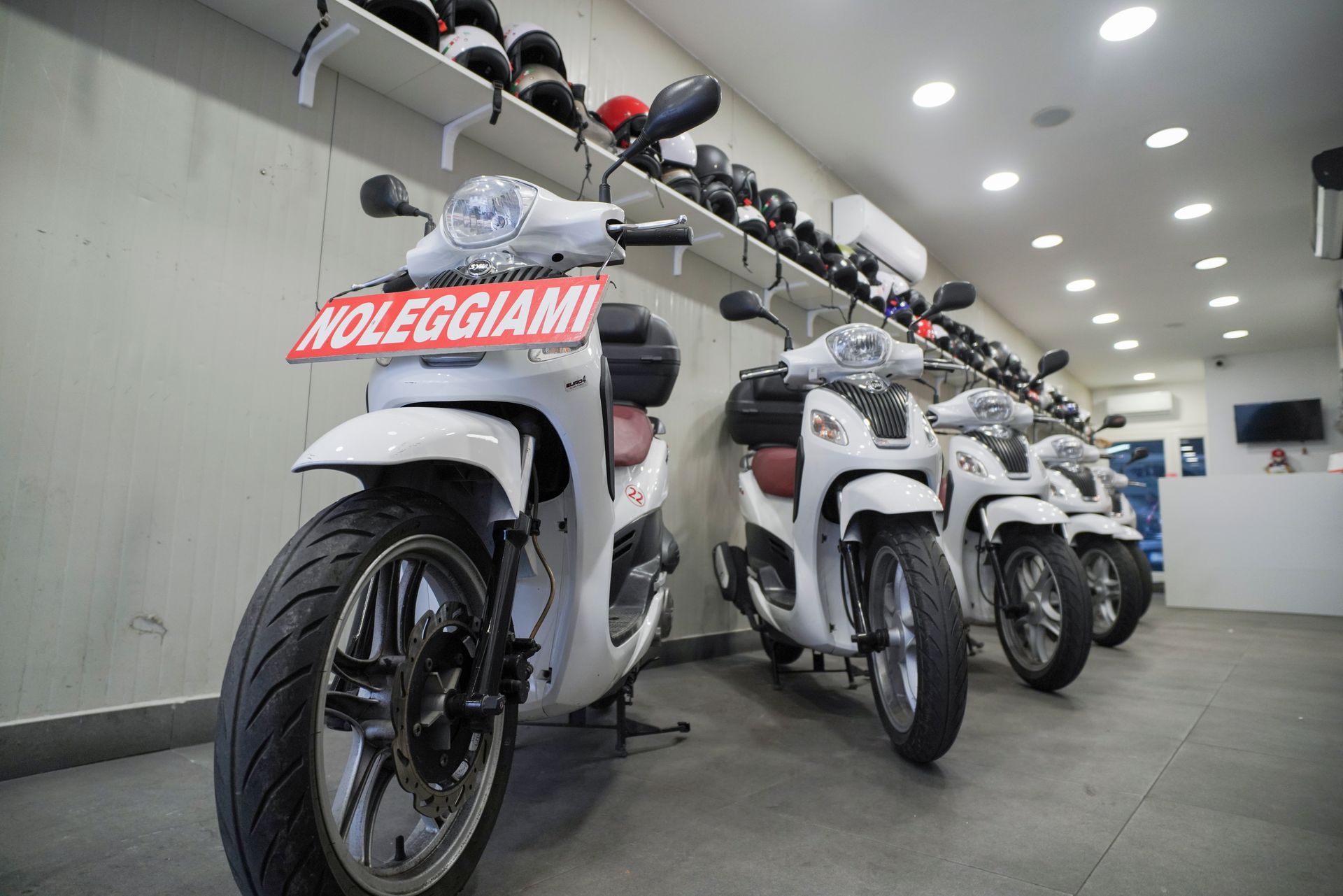 Una fila di motociclette bianche sono parcheggiate in una stanza.