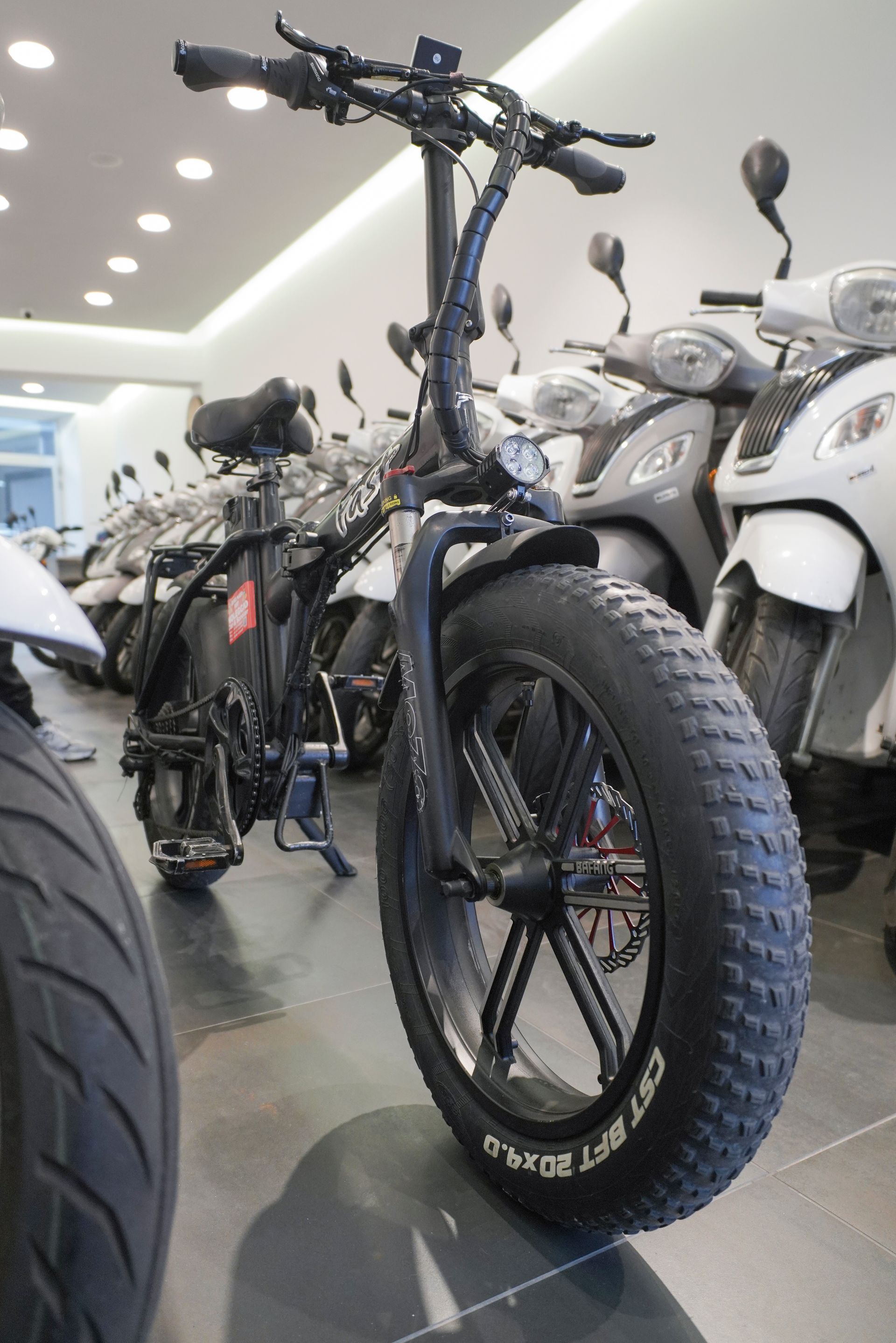 Una motocicletta con una gomma grande è parcheggiata in uno showroom.
