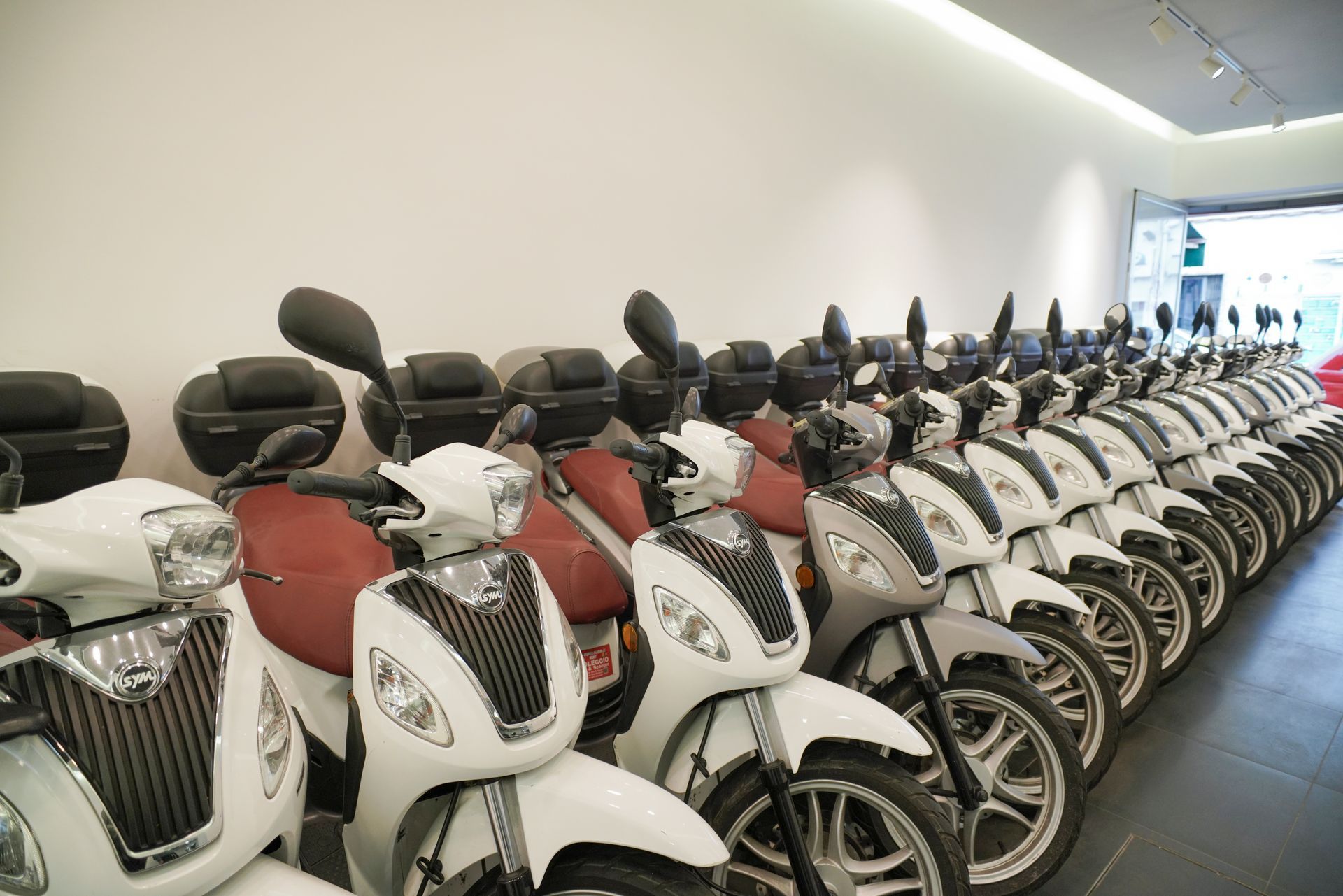 Una fila di scooter sono parcheggiati in uno showroom.
