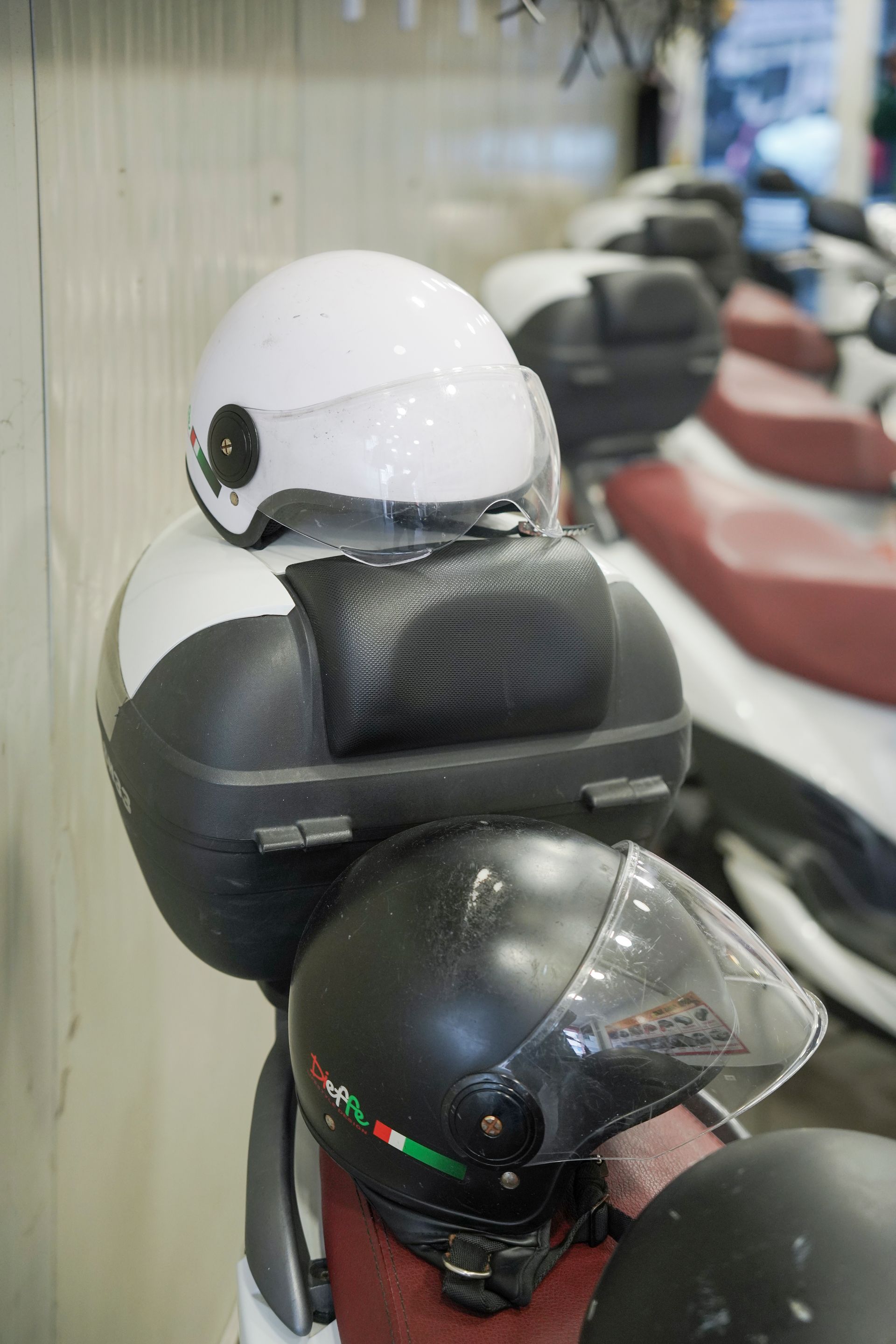 Un casco bianco è posizionato sopra un casco nero su una motocicletta.