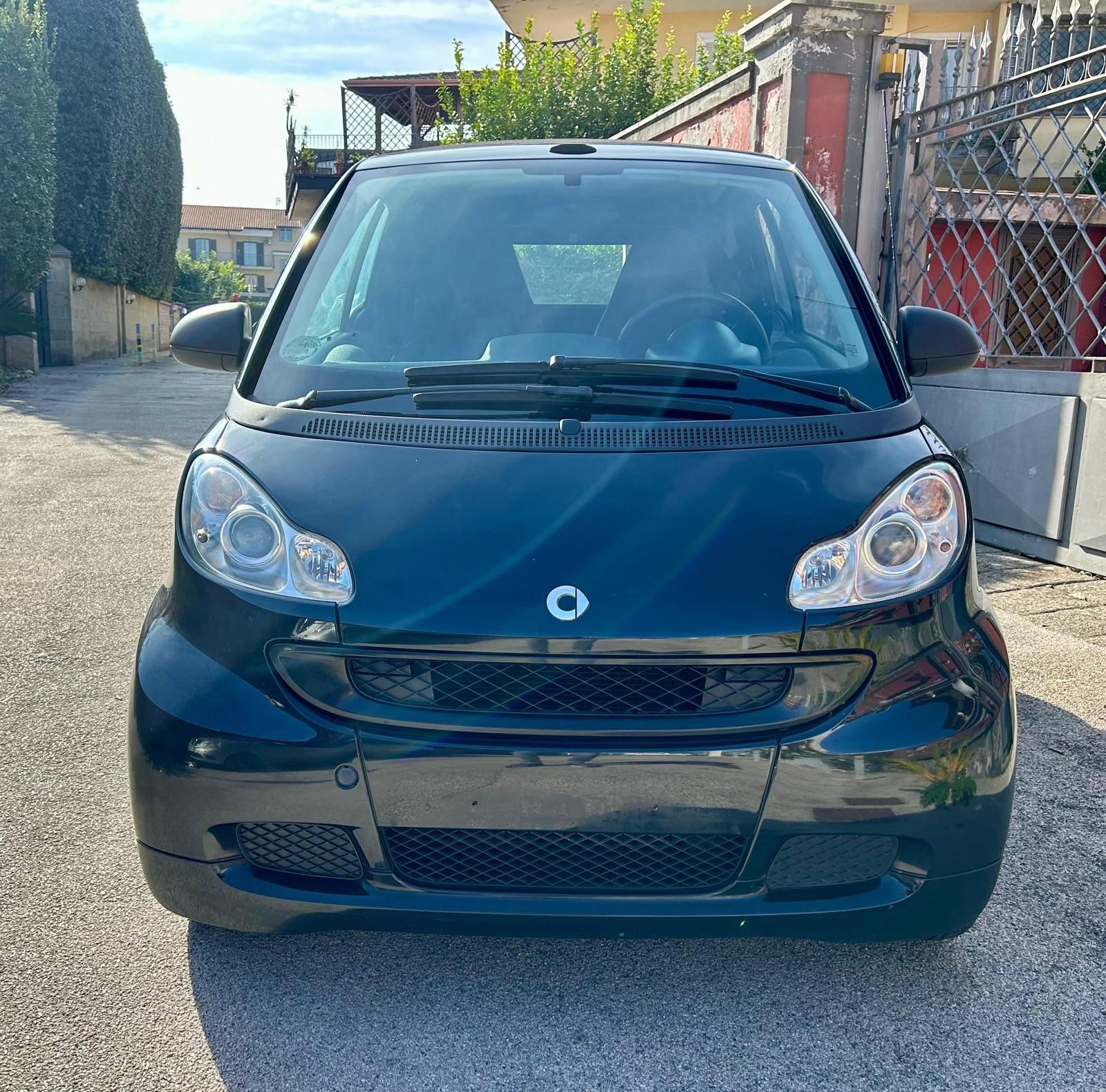 Una smart bianca con capote su sfondo bianco