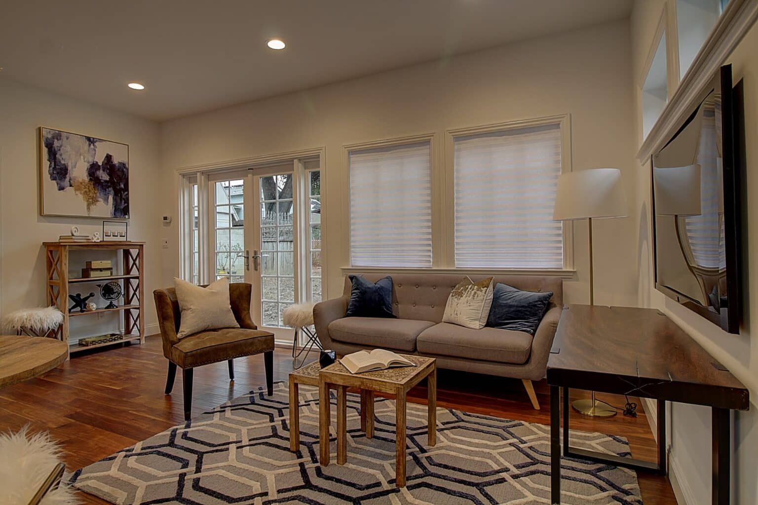 A living room with a couch , chairs , table and television.
