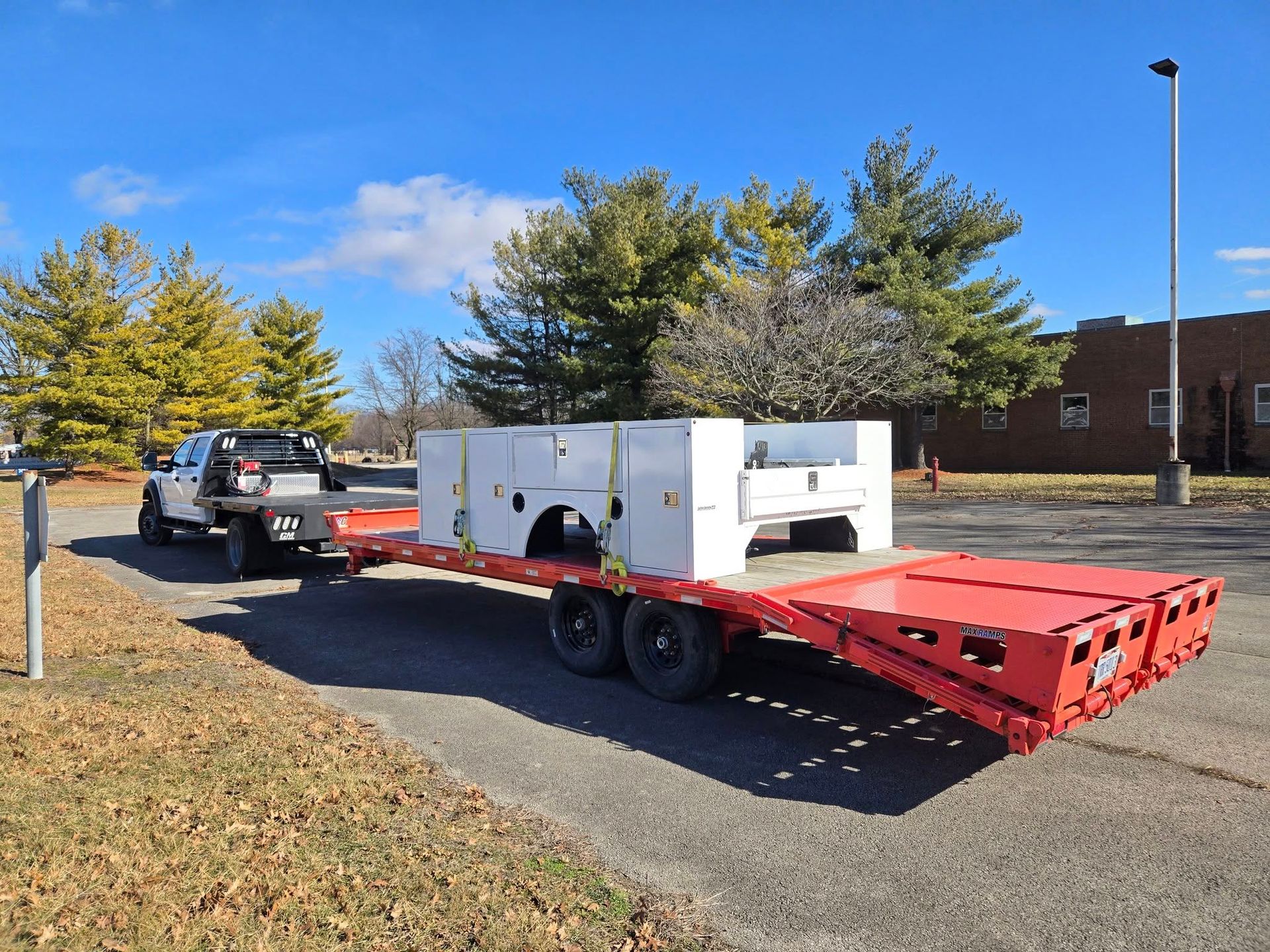 A truck is towing a trailer with a ramp attached to it.