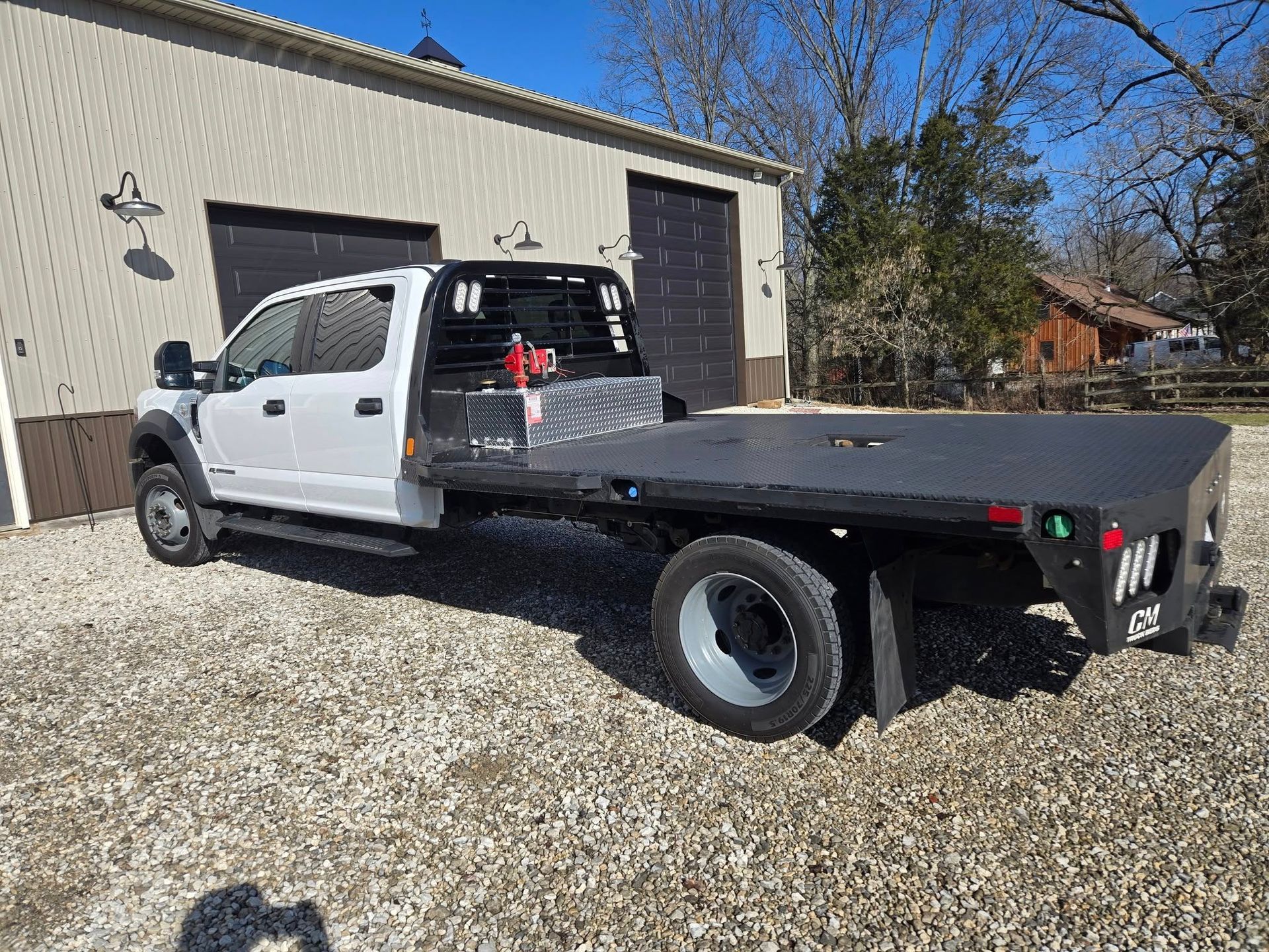 A flatbed truck is parked in front of a building.