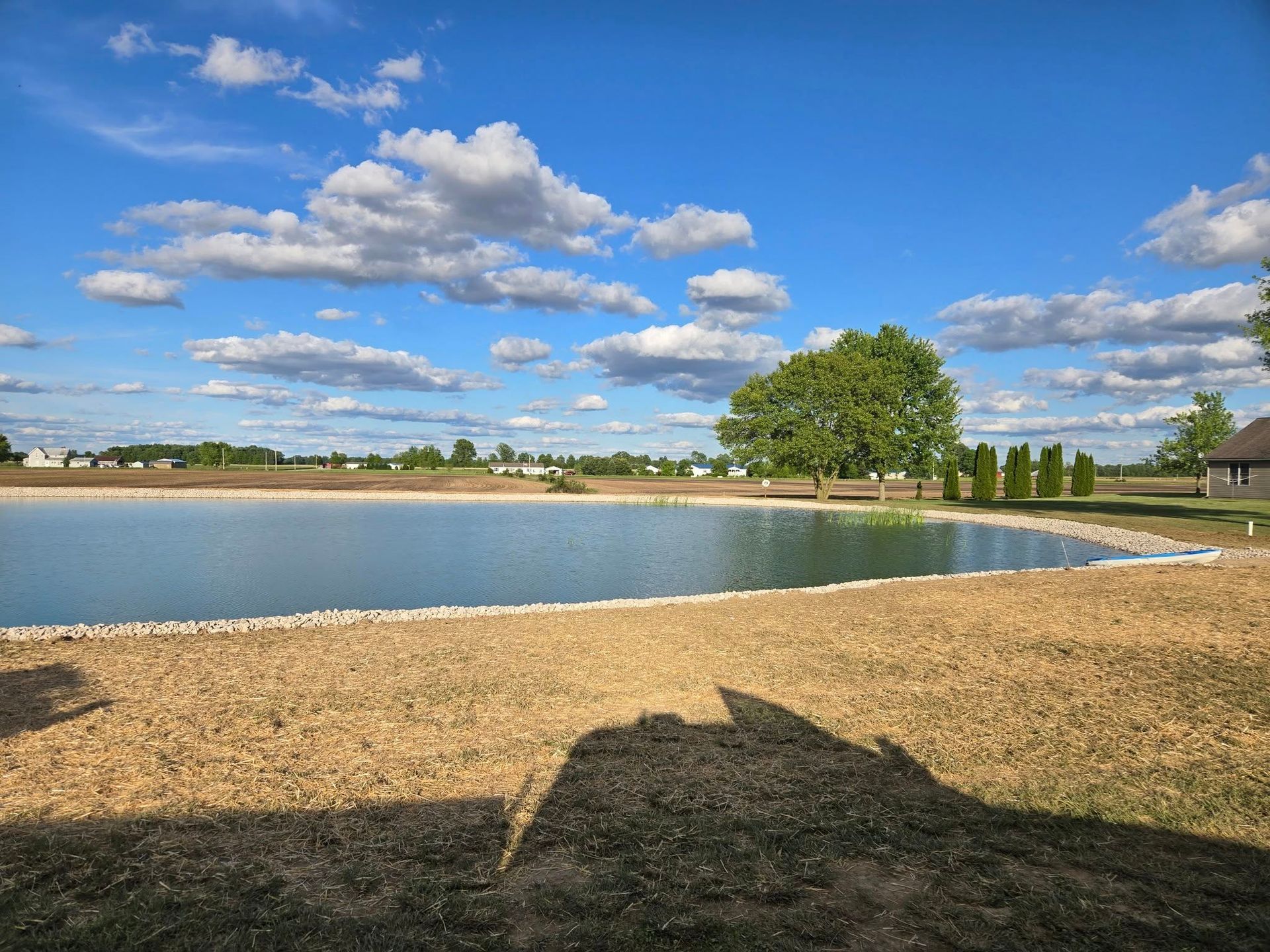 A large body of water with a blue sky and clouds in the background