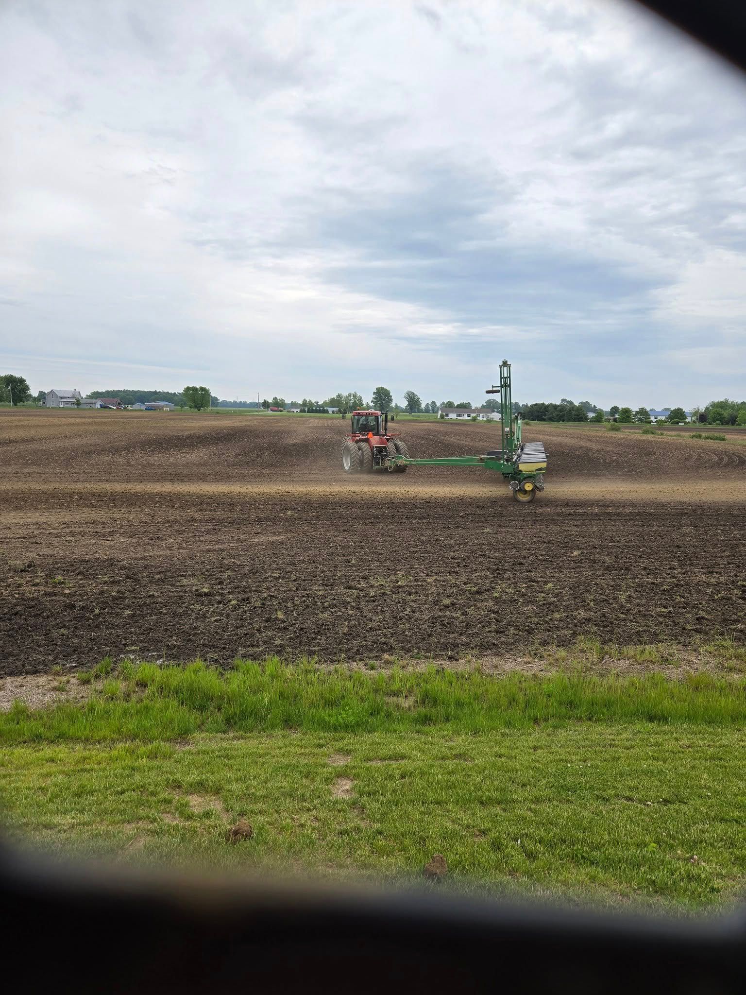 A tractor is plowing a field with a plow in the background.