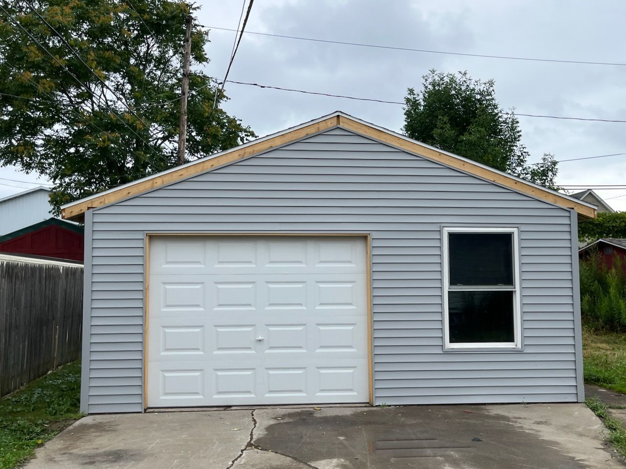 A gray garage with a white garage door and a window