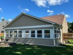 A small house with a screened in porch in the backyard