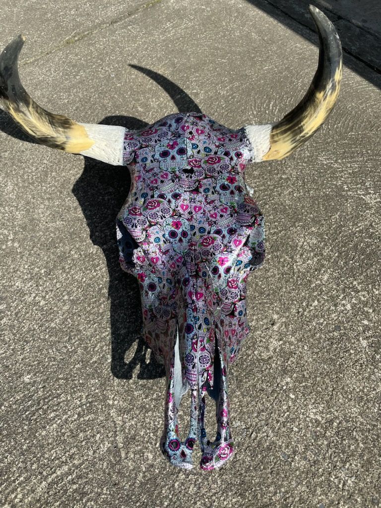 Wooden table with a river of red and purple epoxy in the center, set outdoors.