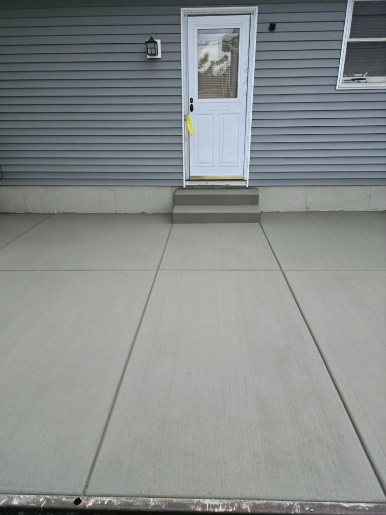 A gray house with a white door and steps