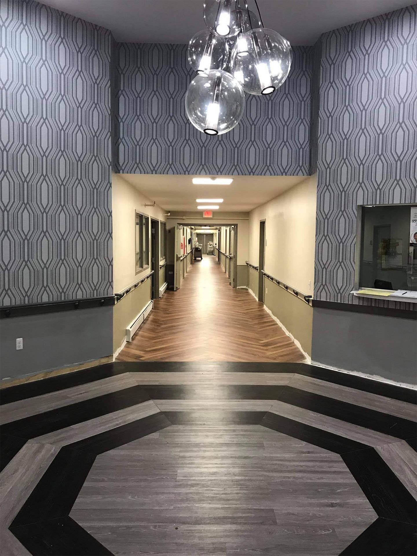 A long hallway in a building with a chandelier hanging from the ceiling