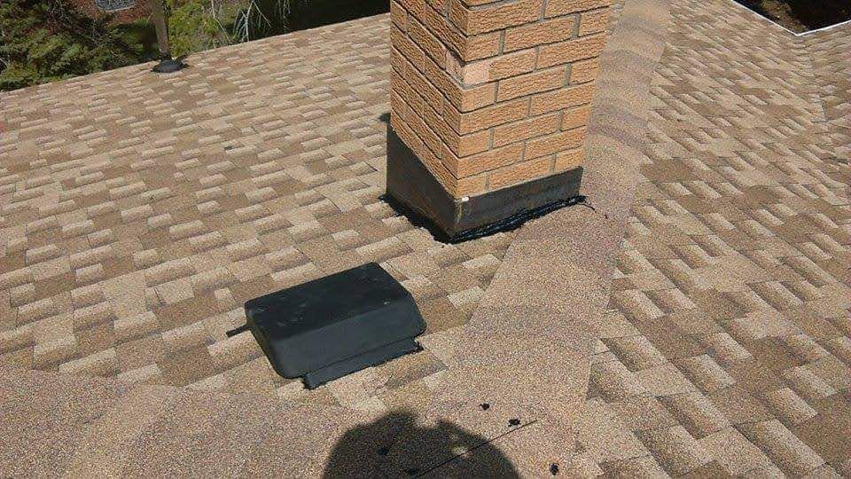 A brick chimney is sitting on top of a roof