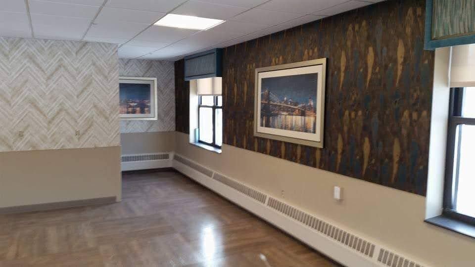 A long hallway with a lot of windows and a picture on the wall