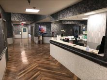 A lobby with a reception desk and a wooden floor