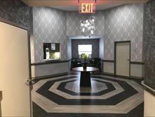 A large hallway with a round table in the middle and an exit sign