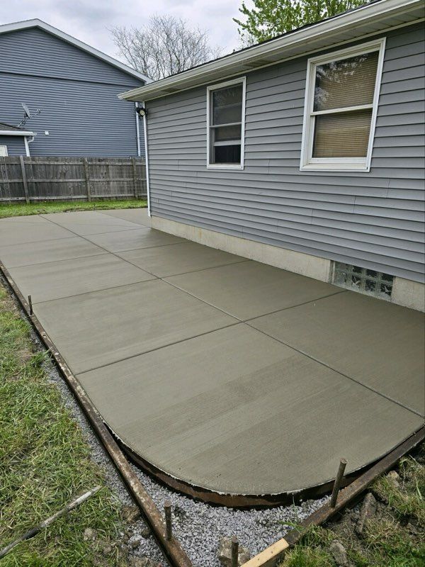 A concrete driveway is being built in front of a house