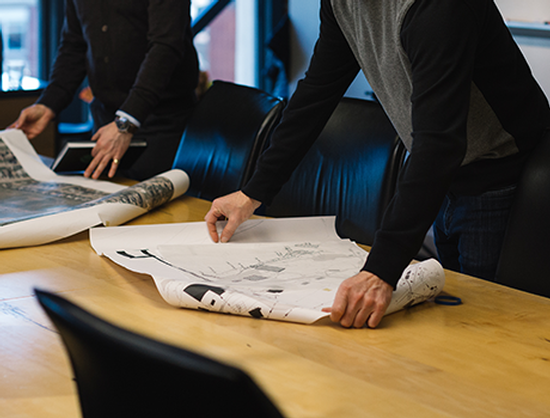 A group of people are looking at a map on a table.