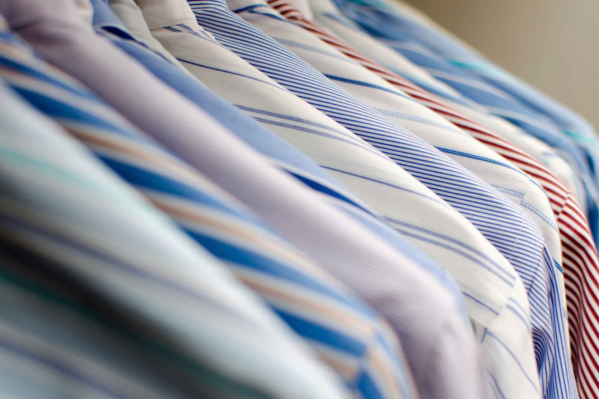 A Row Of Shirts And Ties Hanging On A Rack – Margate, QLD - Ocean Breeze Dry Cleaners