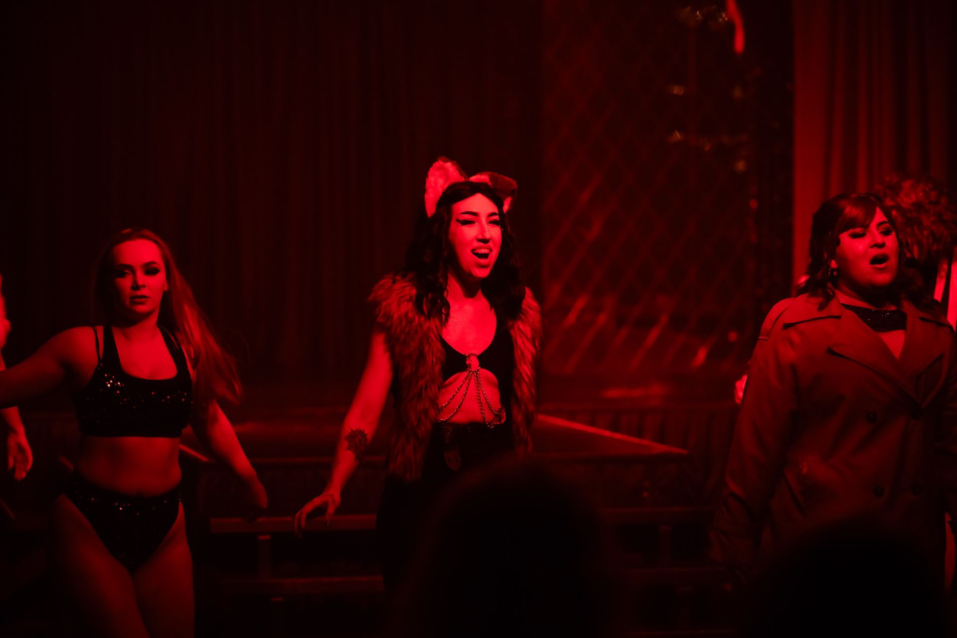 A group of women are dancing in a dark room with red lights— Lux Noir in Townsville City, QLD