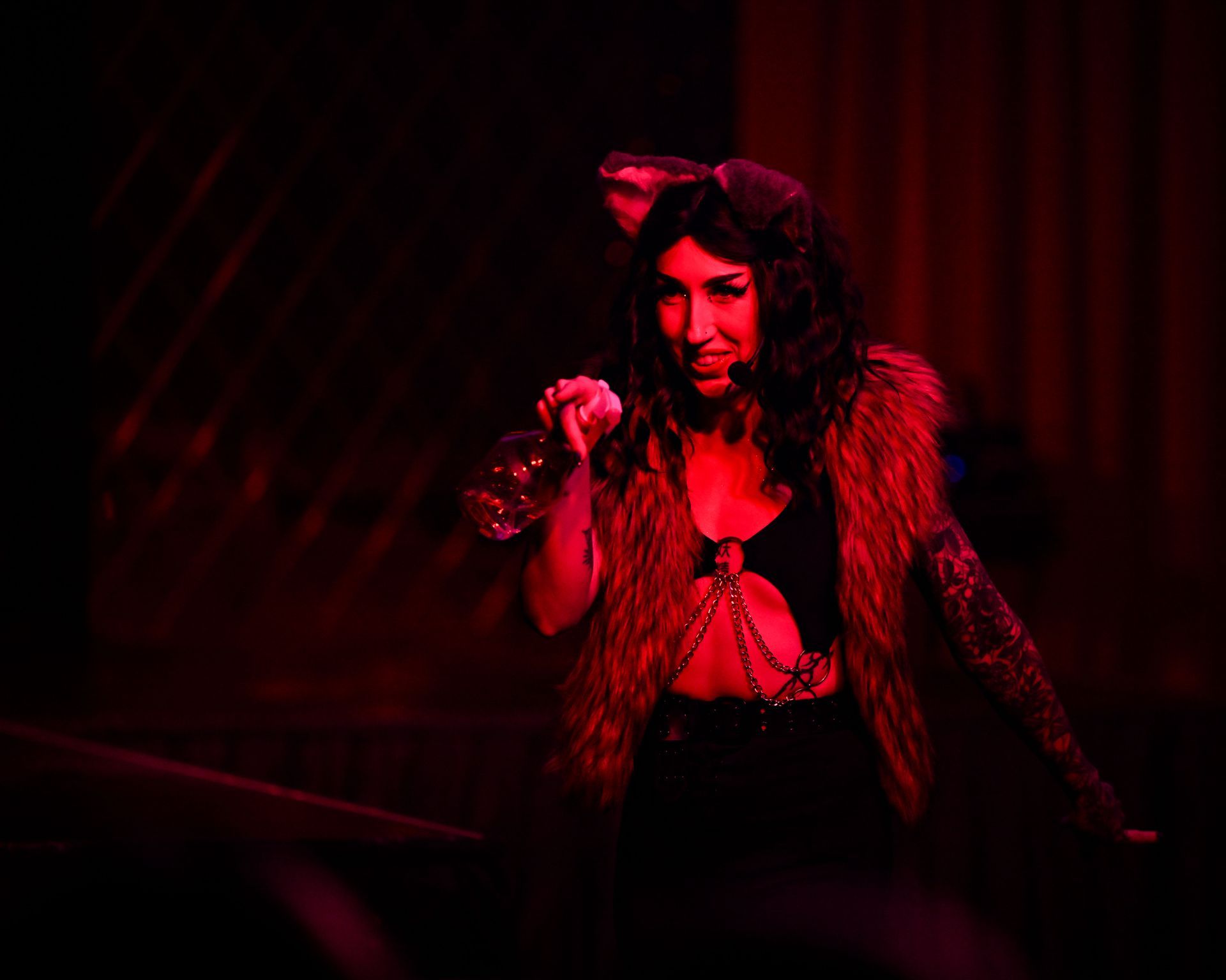 A woman is standing on a stage in a dark room holding a microphone — Lux Noir In  Townsville City, QLD