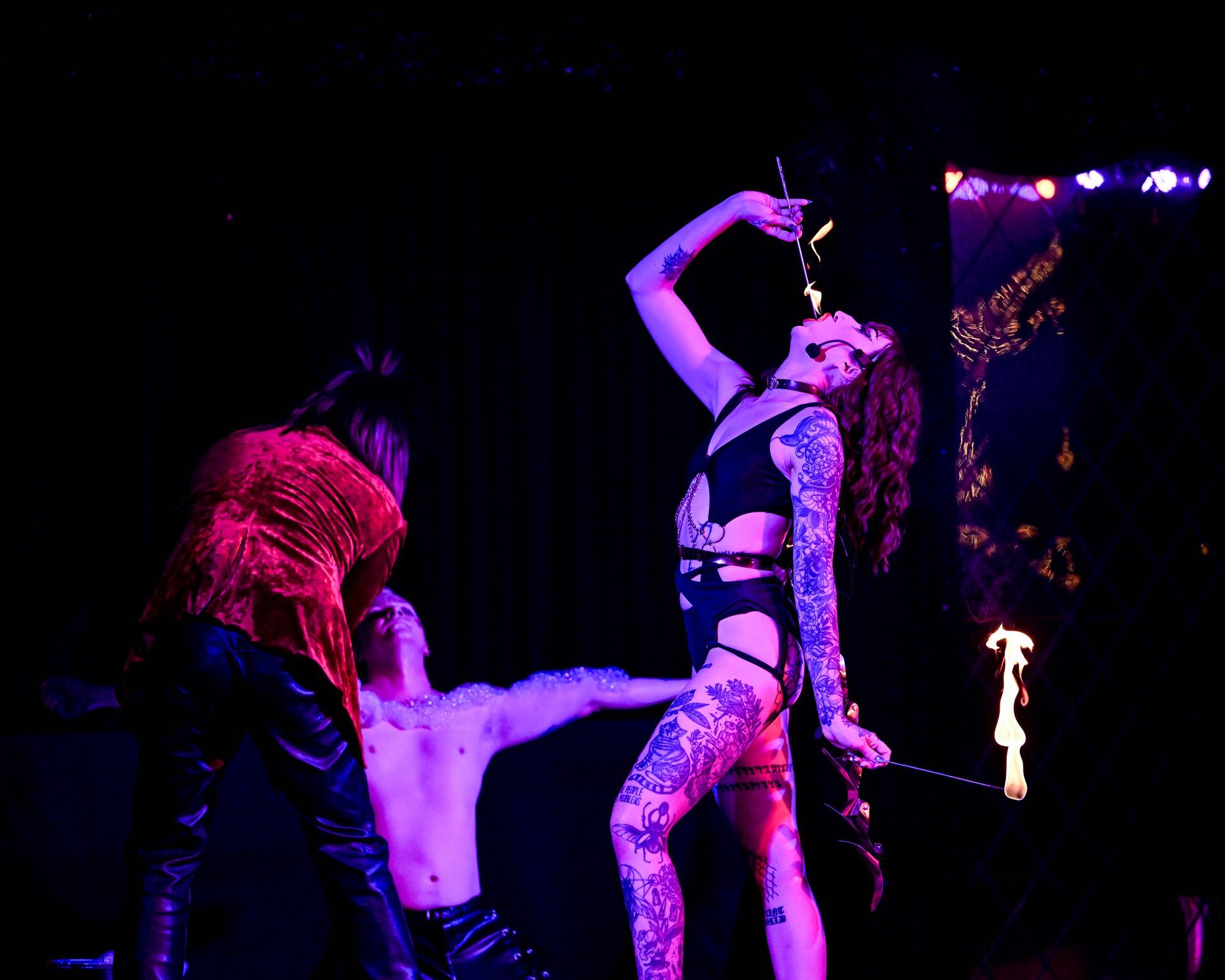 A group of people are dancing on a stage in a dark room— Lux Noir in Townsville City, QLD