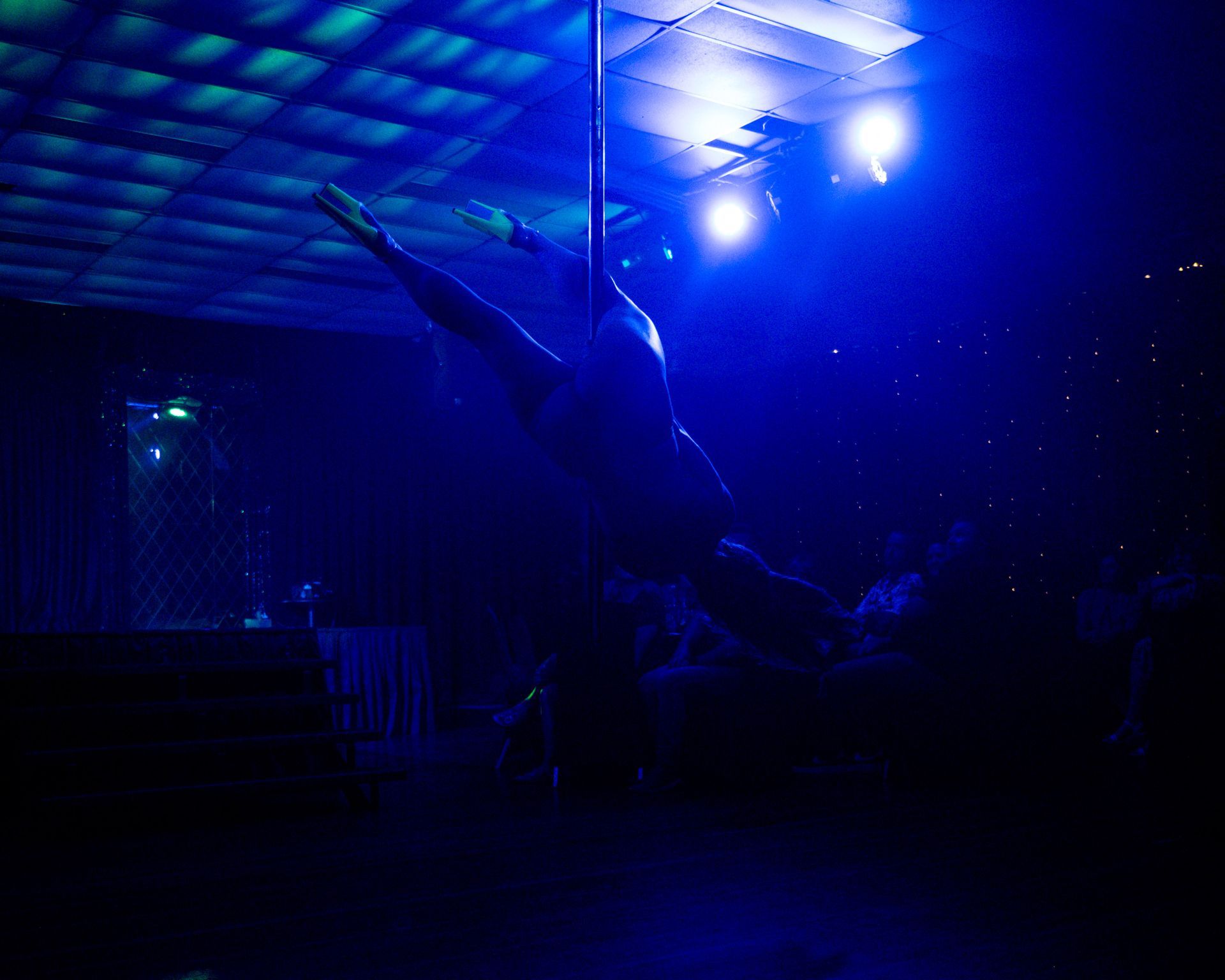 A woman is dancing on a pole in a dark room— Lux Noir in Townsville City, QLD