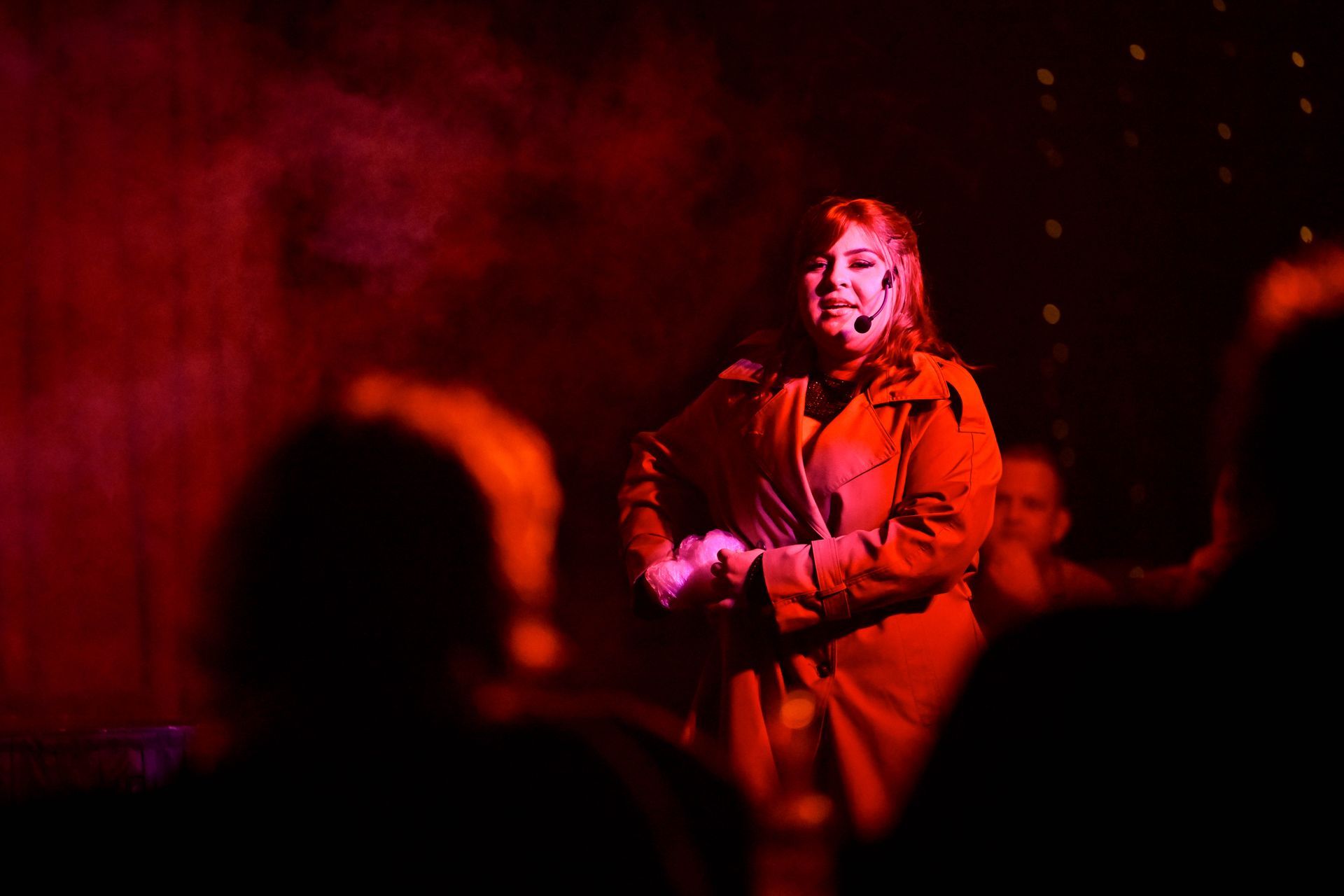 A woman is standing on a stage with a microphone in her hand.